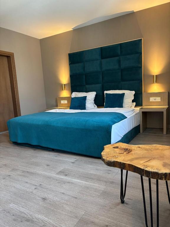 ケルステルバッハにあるHotel Athen Kelsterbach Frankfurt Airportのベッドルーム(青い大型ベッド1台、テーブル付)