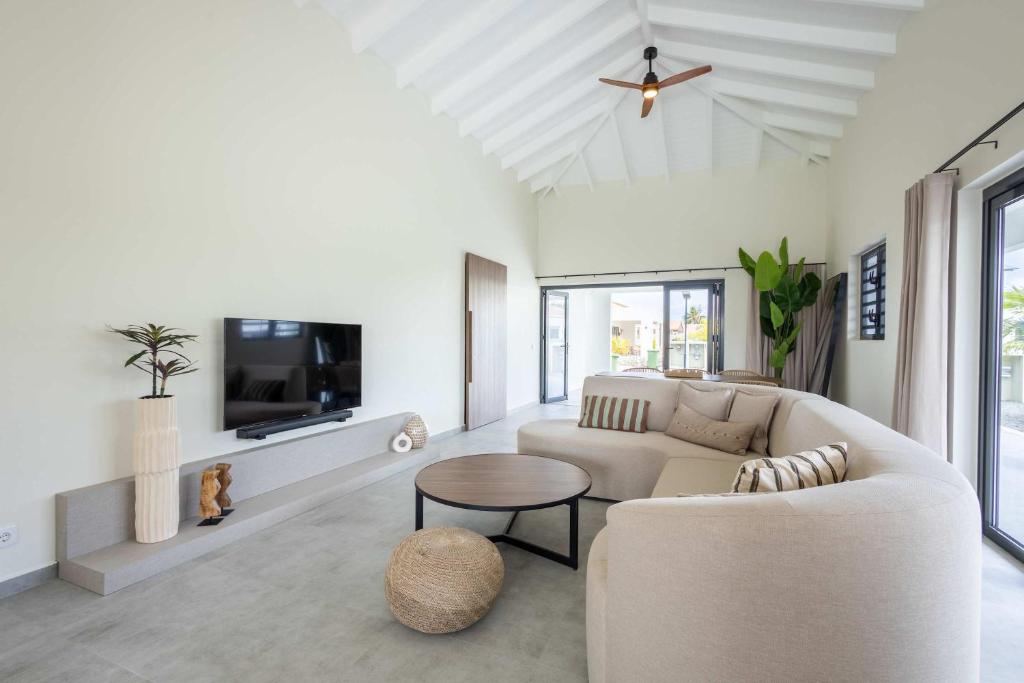 een woonkamer met een bank en een tv bij Villa Kura Cura - 5 Minutes From Mambo Beach in Willemstad