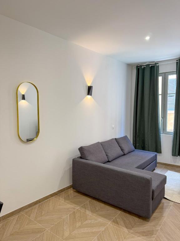 un salon avec un canapé et un miroir dans l'établissement T1 luxury Port Toulon Clim, Wi-Fi, à Toulon
