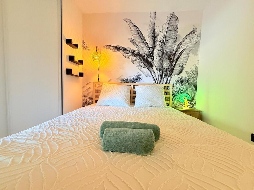 een bed met een groene handdoek erop bij Appartement Jungle 2 chambres - terrasse clim parking et piscine in Antibes