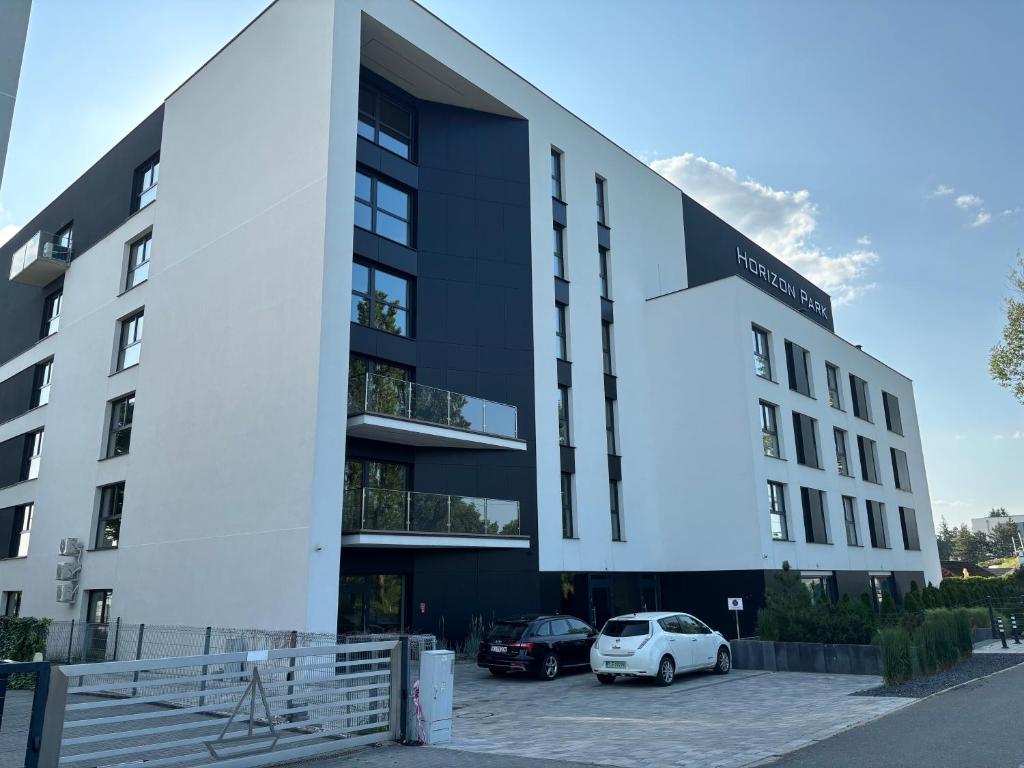 a building with cars parked in a parking lot at Horizon Park 33 Boszkowo in Boszkowo