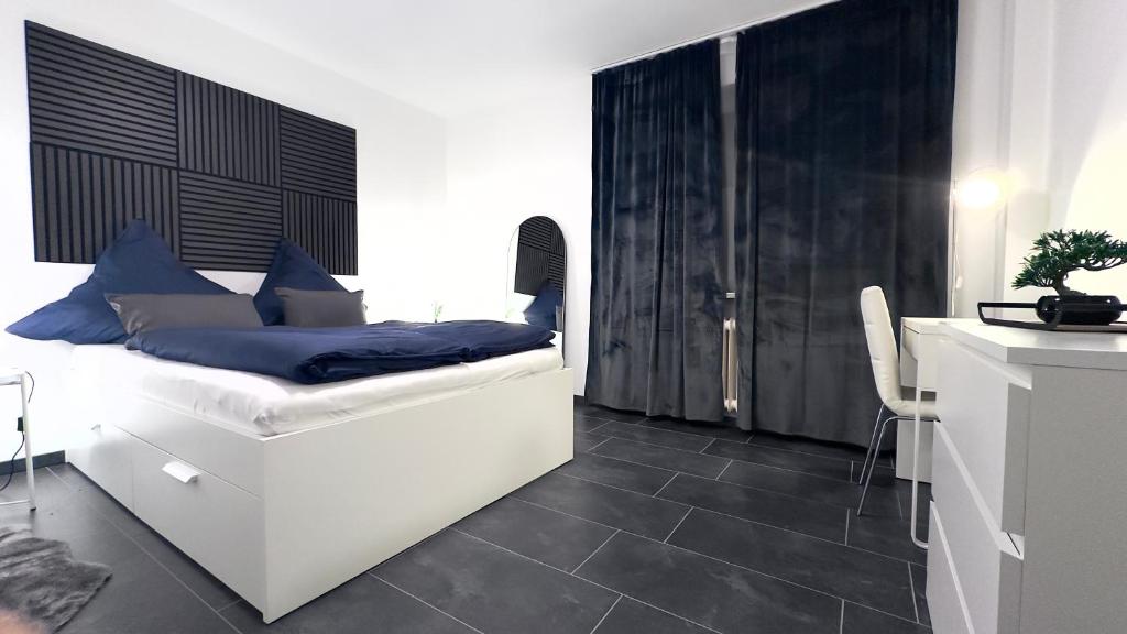 a bedroom with a bed with blue pillows on it at Kassel - Modernes Apartment in Fuldatal mit Parkplatz & WLAN - OneN8 in Fuldatal