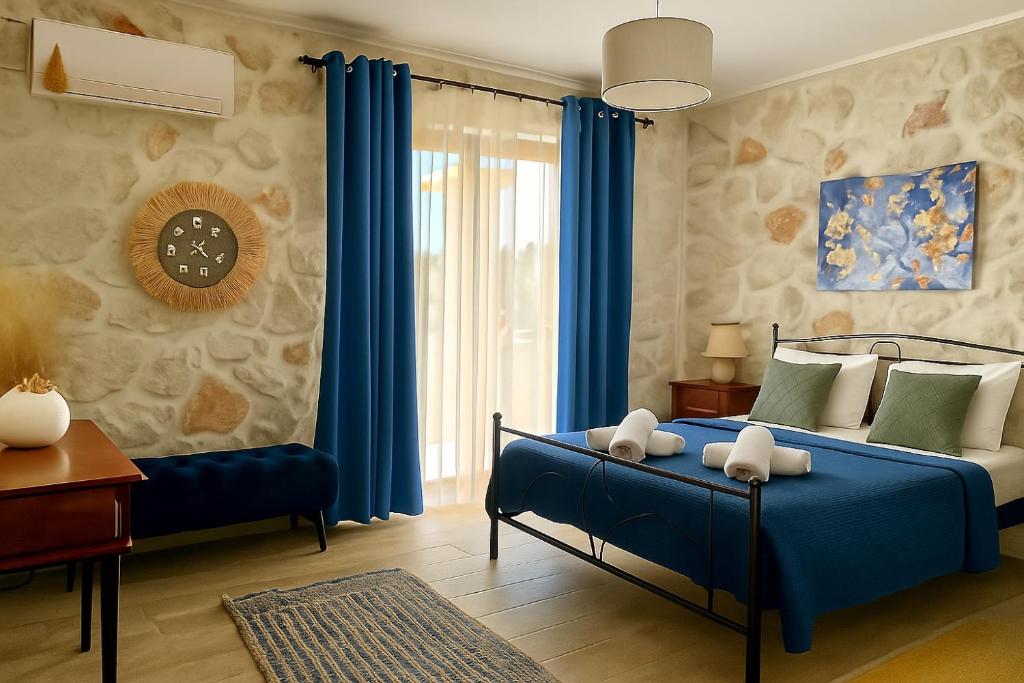 a bedroom with a blue bed and blue curtains at La Casa Del Sole in Agios Leon