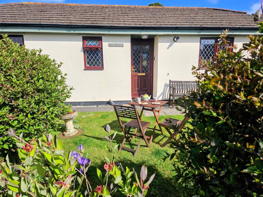 a house with a table and chairs in the yard at Chiffchaff in Padstow