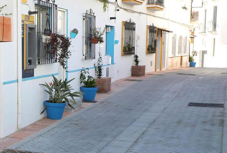 eine leere Straße mit Topfpflanzen an der Seite eines Gebäudes in der Unterkunft Casa pepa in Marbella
