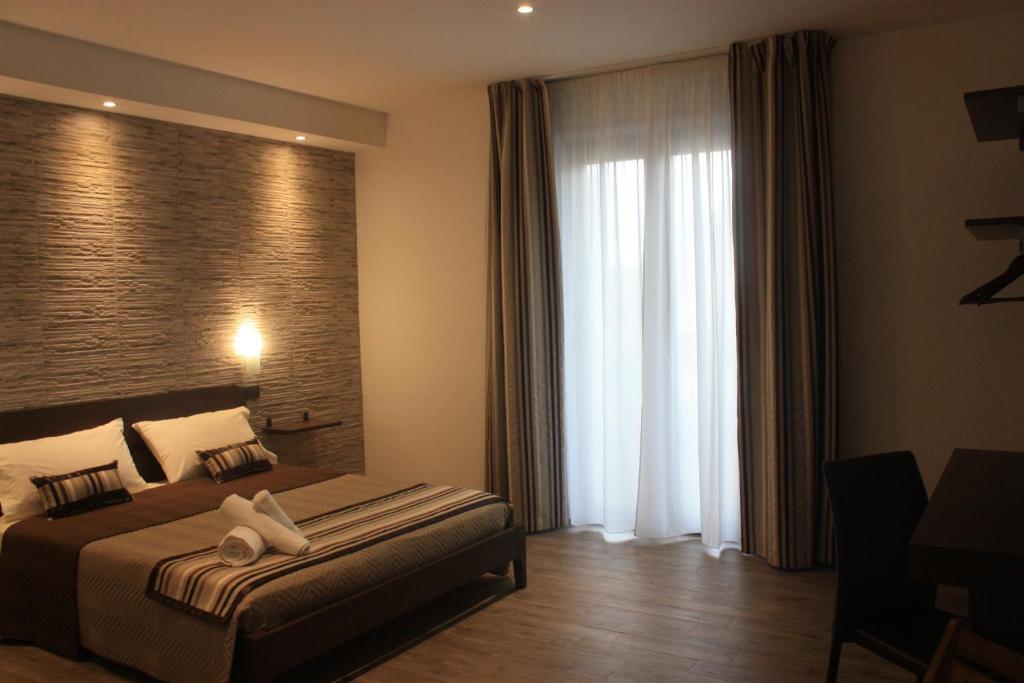 a hotel room with a bed and a large window at Terrazzi in Fiore in Alghero
