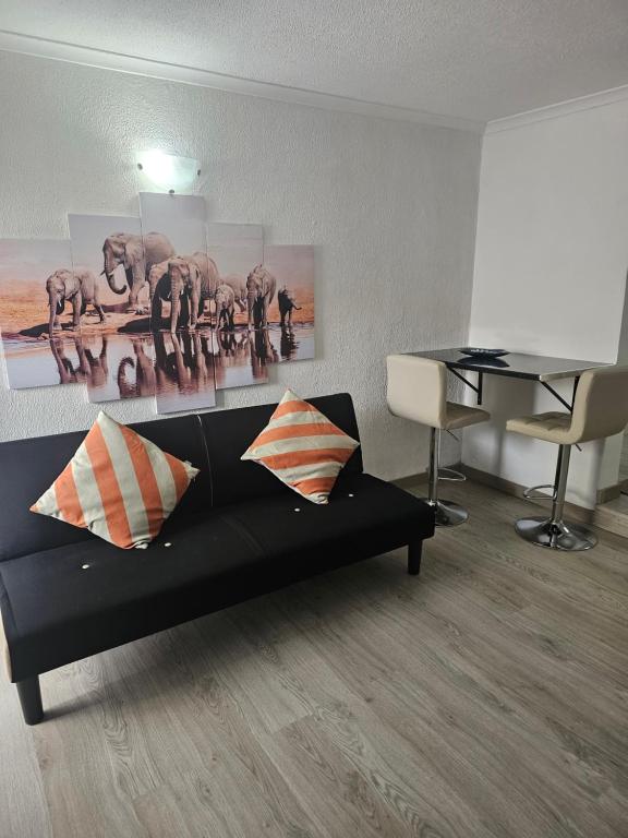 フンシャルにあるApartamento Santa Luciaのリビングルーム(ブラックソファ、ピアノ付)