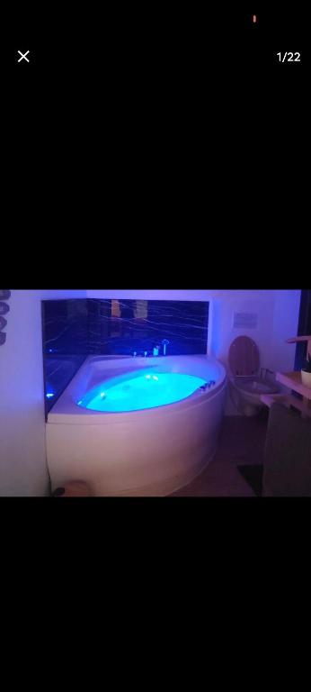 une salle de bain avec une baignoire contenant un liquide vert dans l'établissement Escapade à Blagnac, T2, balnéo,jardin,parking,tram, à Blagnac