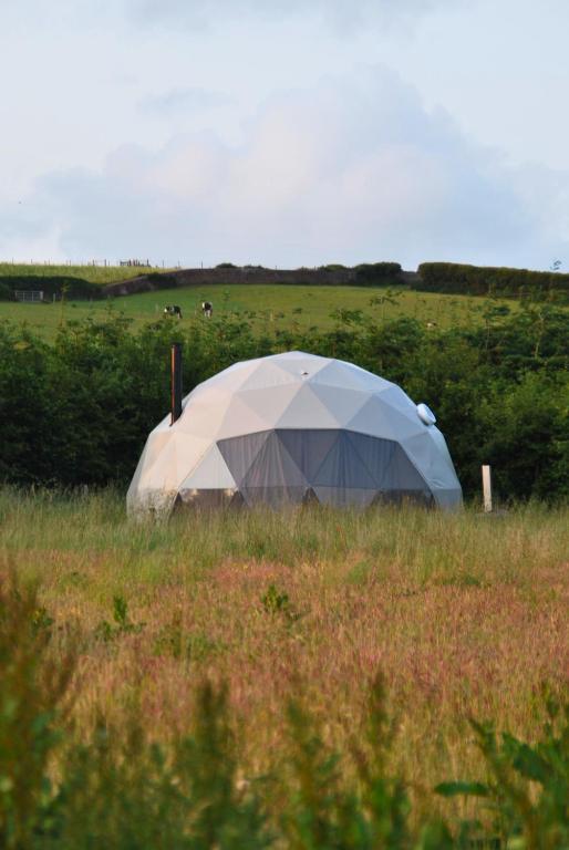 a tent in the middle of a field at Kilima Retreats in West Quantoxhead