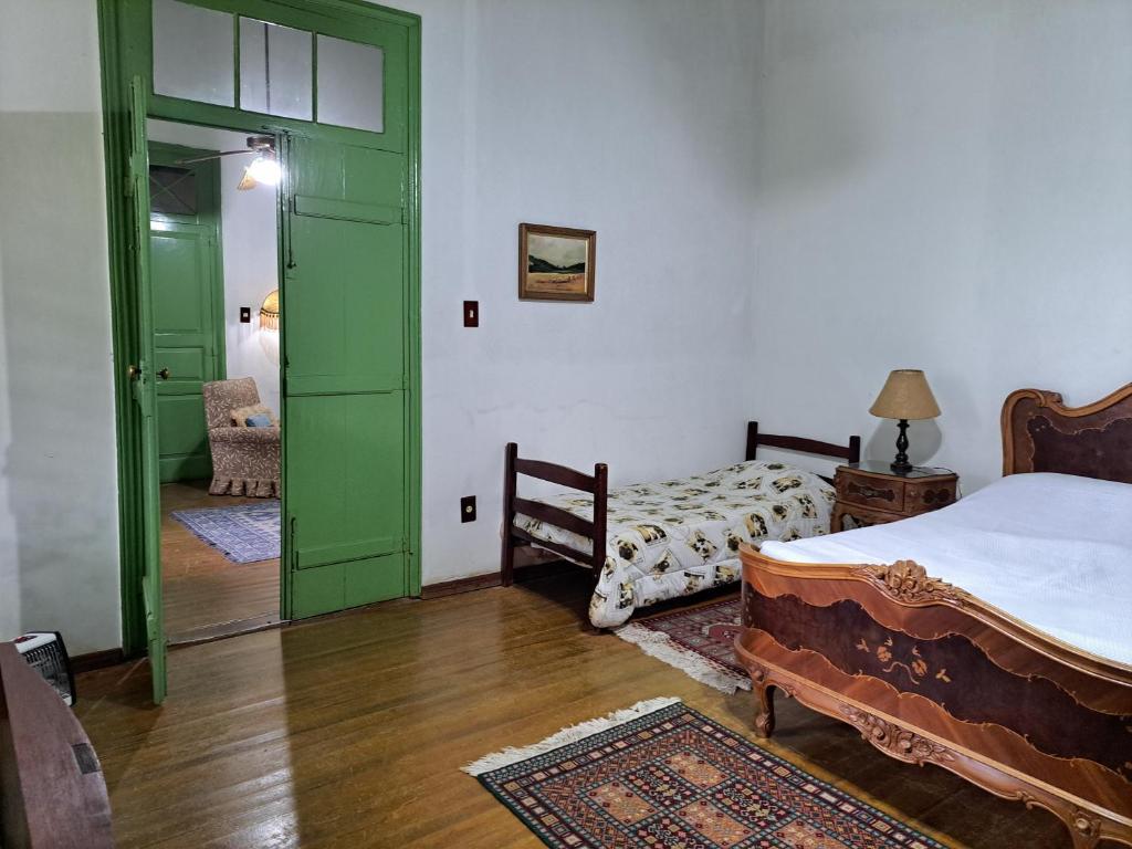 a bedroom with a bed and a green door at Pousada do sobrado in Bagé