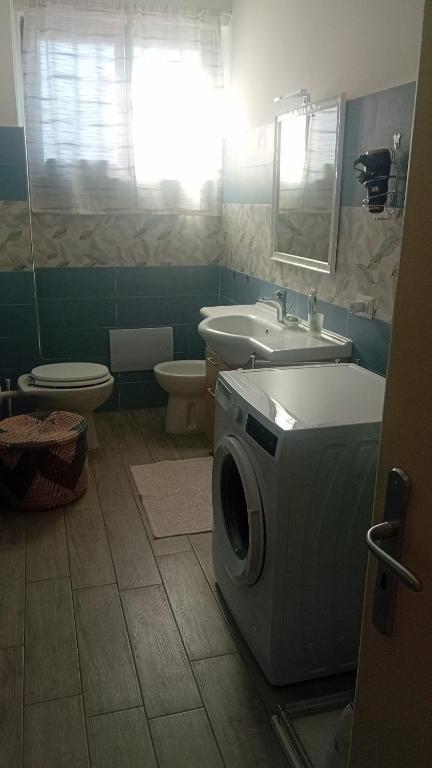 a bathroom with a washer and a sink and a washing machine at A casa di paola in Naples
