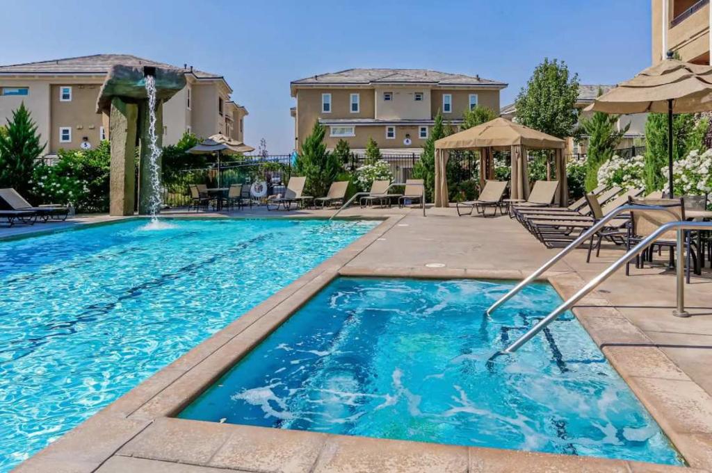a swimming pool with chairs and umbrellas at a hotel at NEW Chic 2BR Stay with Heated Pool Gym & Mini Golf in Steamboat