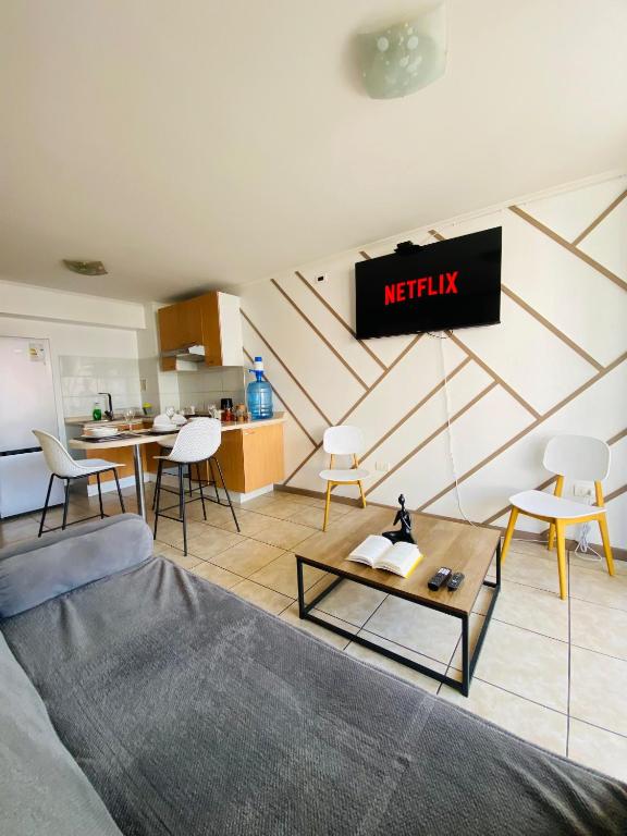 a living room with a couch and a kitchen at Experiencia Vista Urbana 1Hab-1Baño-1 Estac in Antofagasta