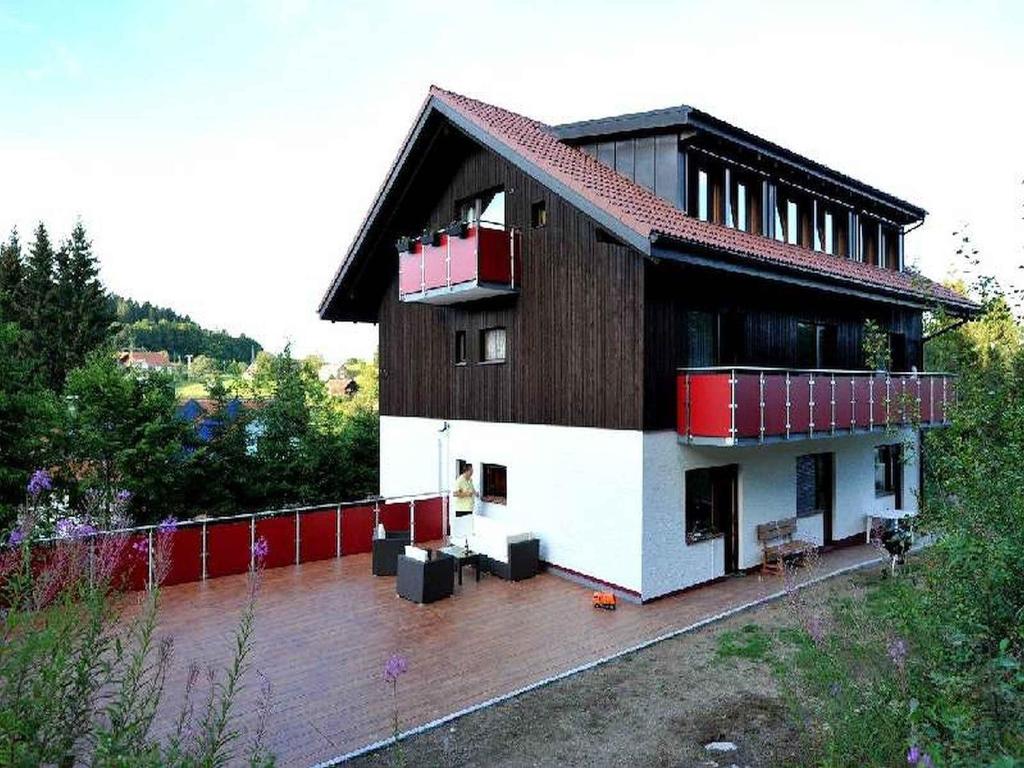 une grande maison avec une terrasse en face de celle-ci dans l'établissement Schlesierhaus, à Dachsberg im Schwarzwald