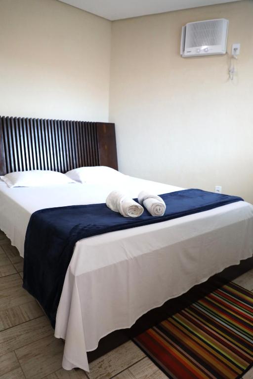 a bedroom with a bed with two towels on it at Casa completa com 2 quartos e enxoval 35C in Sete Lagoas