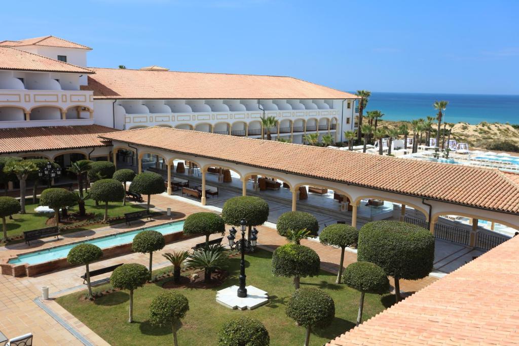 an aerial view of a resort with a pool and trees at Iberostar Selection Andalucia Playa in Chiclana de la Frontera