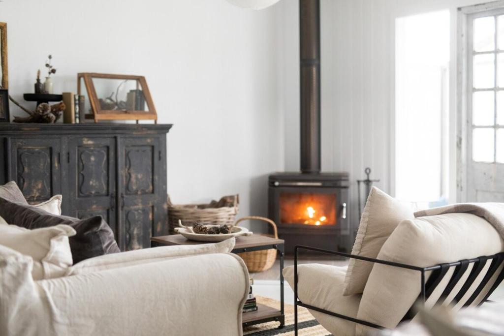 a living room with two chairs and a fireplace at The Reads Freycinet - Water Front Property in Coles Bay