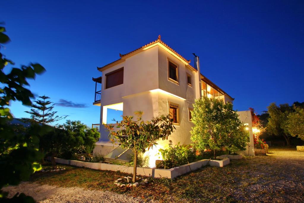 una casa blanca con luces encendidas por la noche en Giasemi Apartments, en Skopelos Town