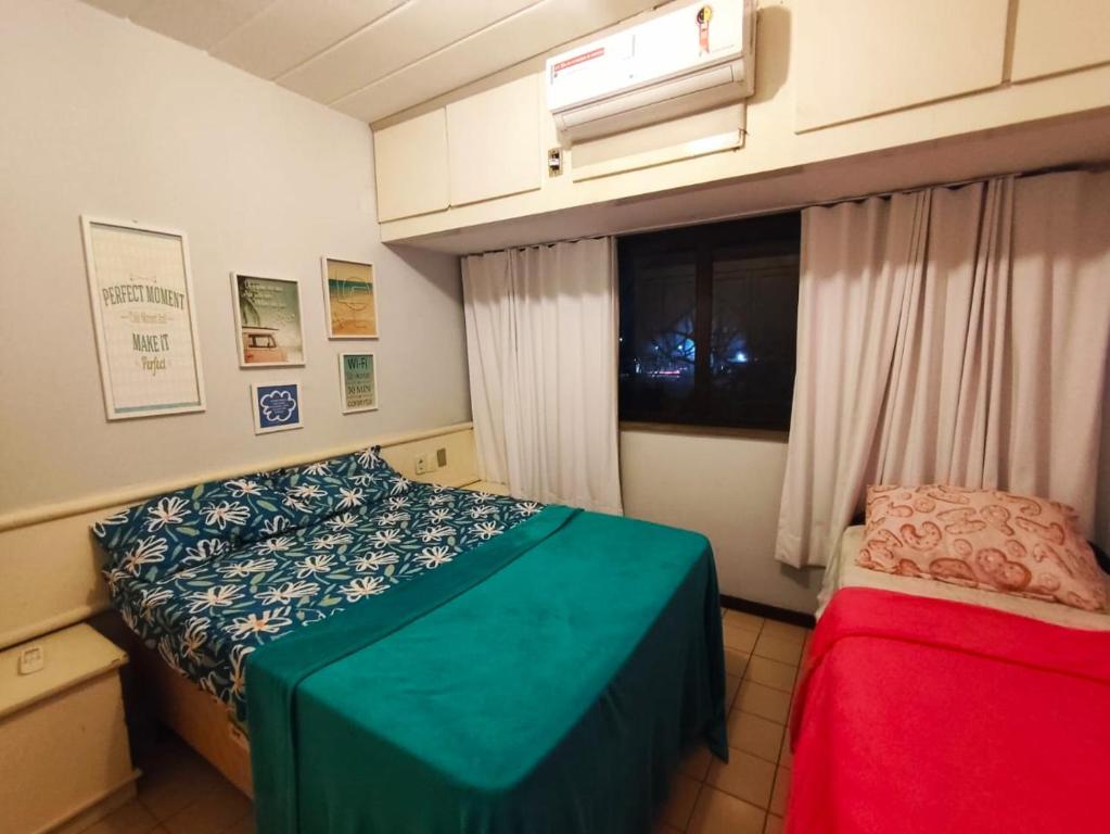 Un dormitorio pequeño con una cama y una ventana. en Summer Guarajuba Praça Principal, en Camassari