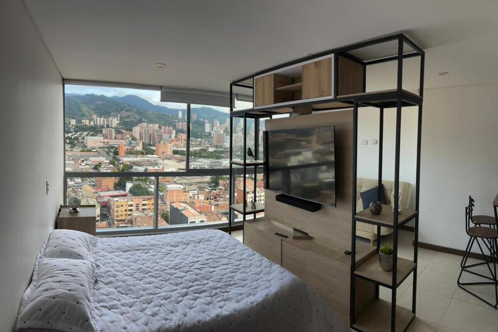 a bedroom with a white bed and a large window at Apartamento Loft con vista unica in Itagüí