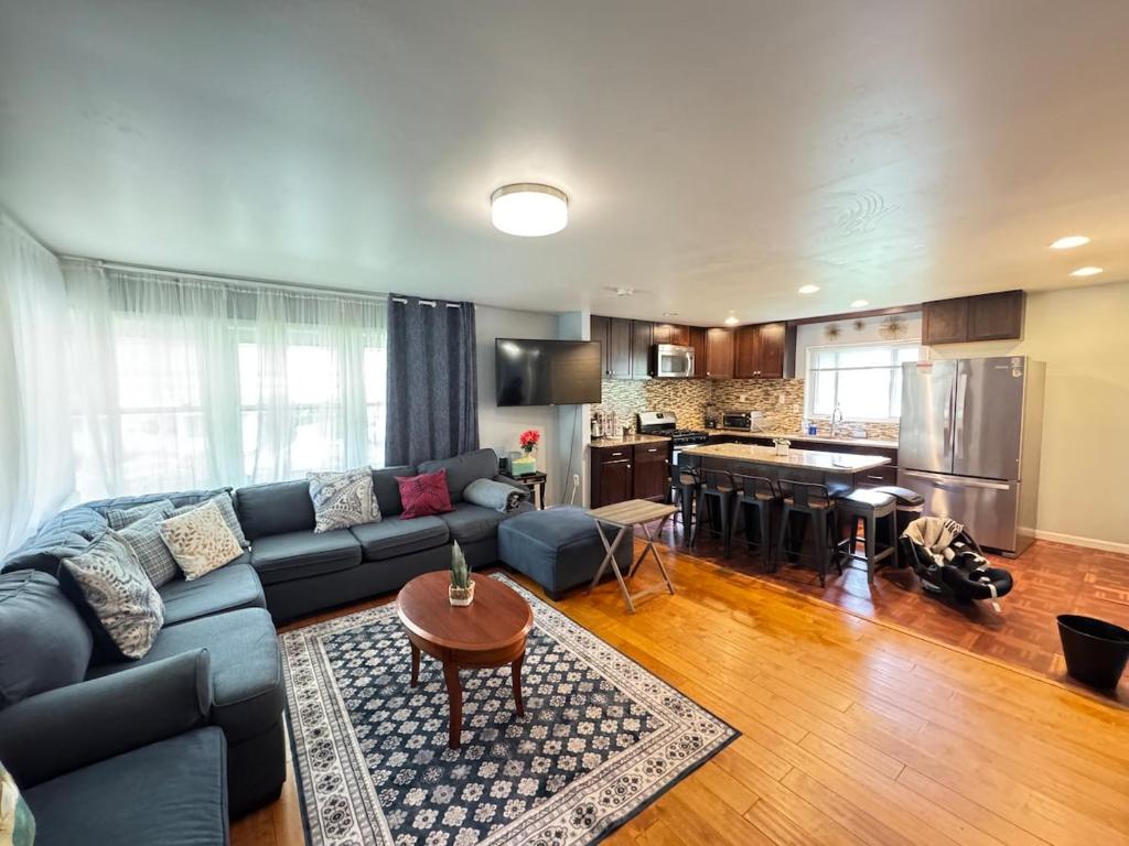 アレクサンドリアにあるCOZY Great Entire 8BR Home in Alexandriaの青いソファとキッチンのあるリビングルーム