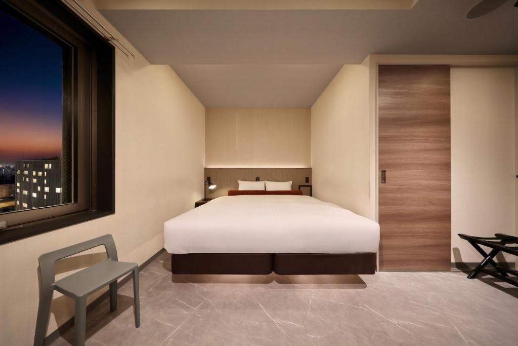 Postel nebo postele na pokoji v ubytování Nippombashi Crystal Hotel Ⅱ