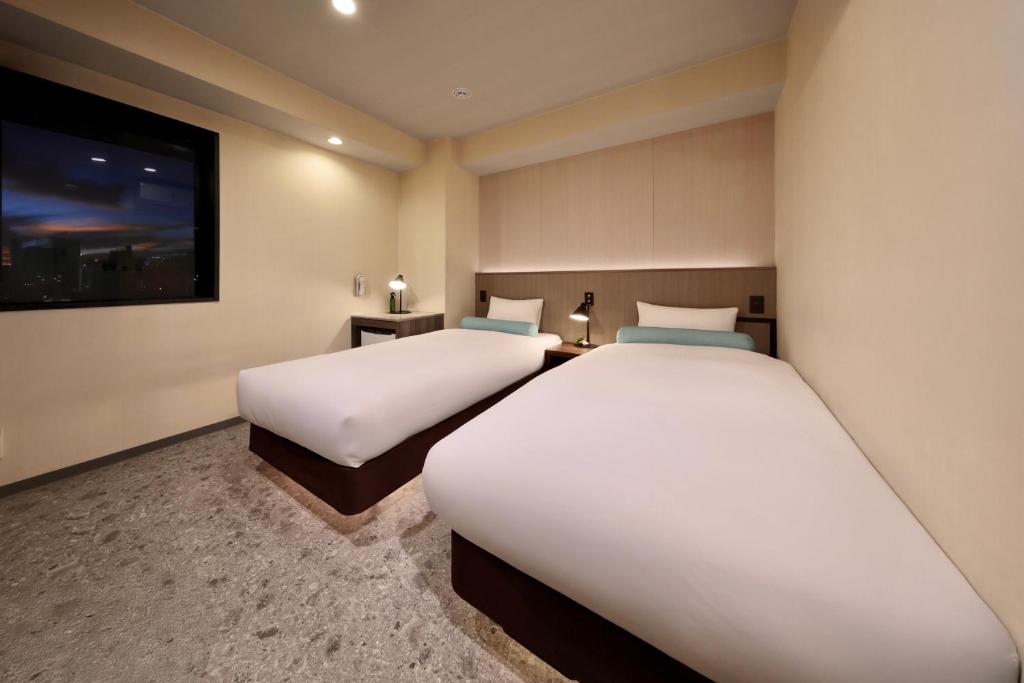 Postel nebo postele na pokoji v ubytování Nippombashi Crystal Hotel Ⅱ