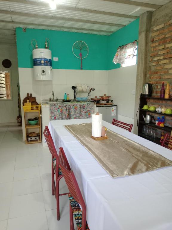 a kitchen with a white table with two red chairs at Cabaña El Tata in Termas de Río Hondo