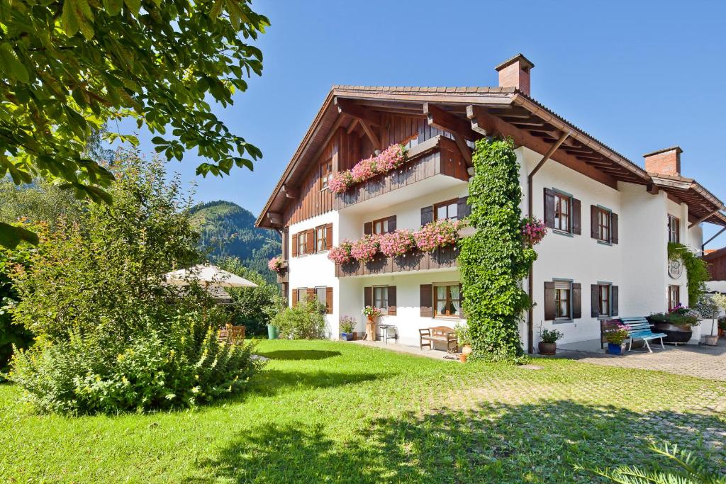 ein großes Haus mit einem grünen Hof in der Unterkunft Landhaus Via Decia - Bad Hindelang PLUS Partner in Bad Hindelang