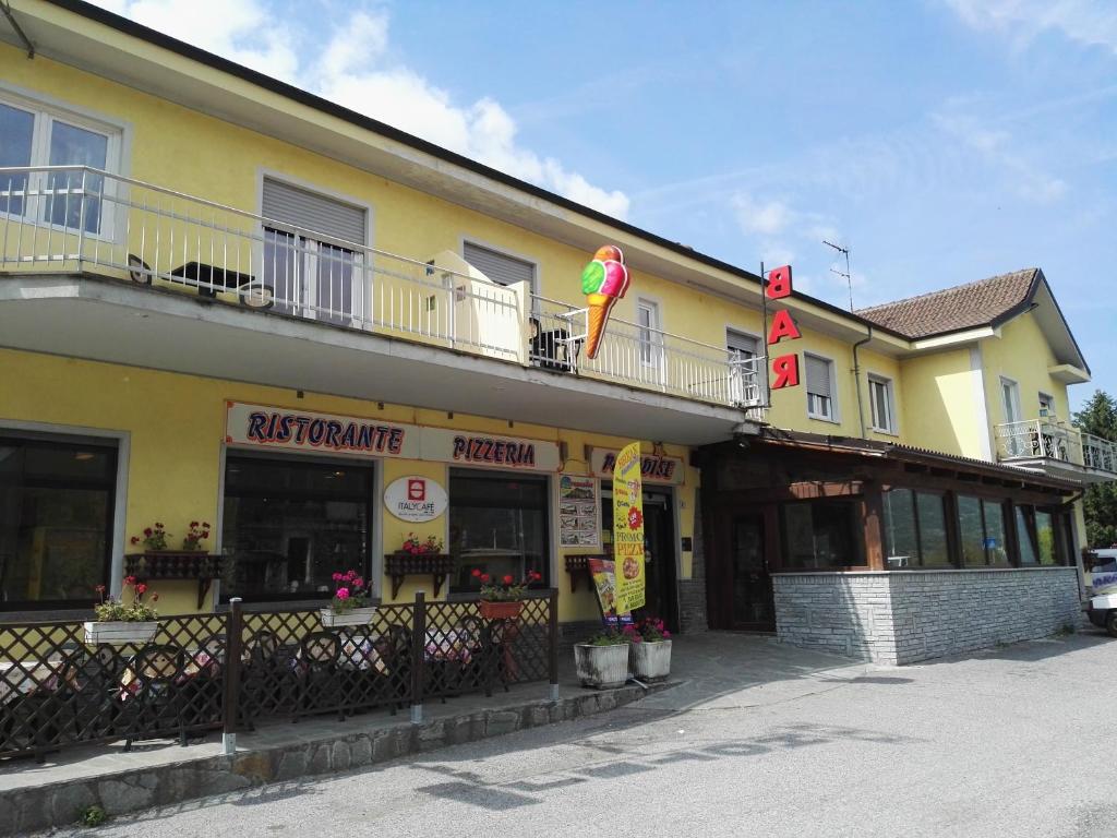 un gran edificio amarillo con balcón en la parte superior en Hotel Paradise en Bruzolo