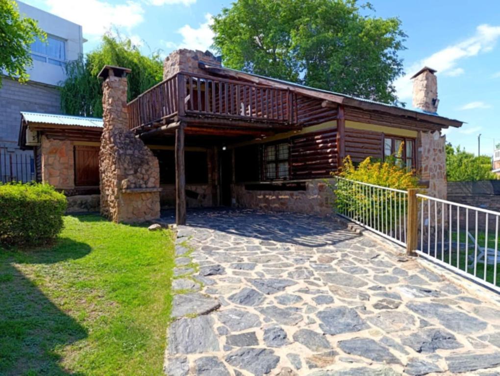 una casa con un ponte e un patio in pietra di Cabañas Postal de la Villa a Villa Carlos Paz