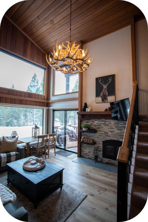 a living room with a fireplace and a chandelier at Summit by 101 Great Escapes in Mammoth Lakes