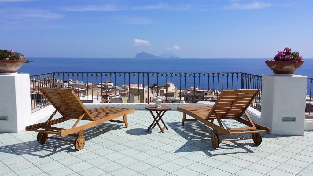 2 sillas y una mesa en un balcón con vistas al océano en La Zagara Hotel, en Lipari