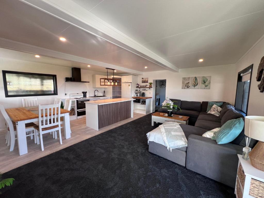 a living room and kitchen with a couch and a table at TAT's Place in Coopers Beach