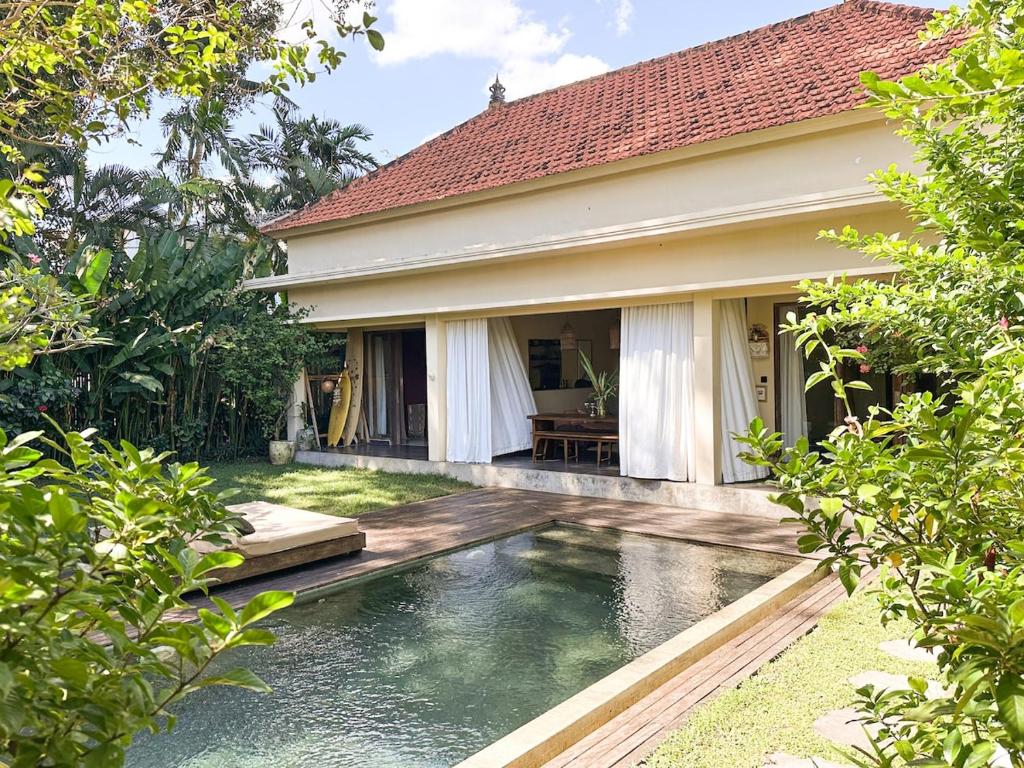 a house with a swimming pool in front of a house at Tropical Escape 2min Walk to Beach and Private Pool in Cemagi