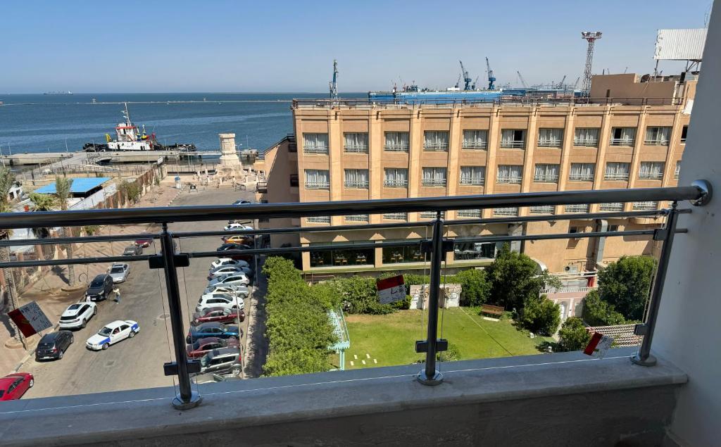 un balcón con vistas a un aparcamiento y a un edificio en بورسعيد, en Puerto Saíd