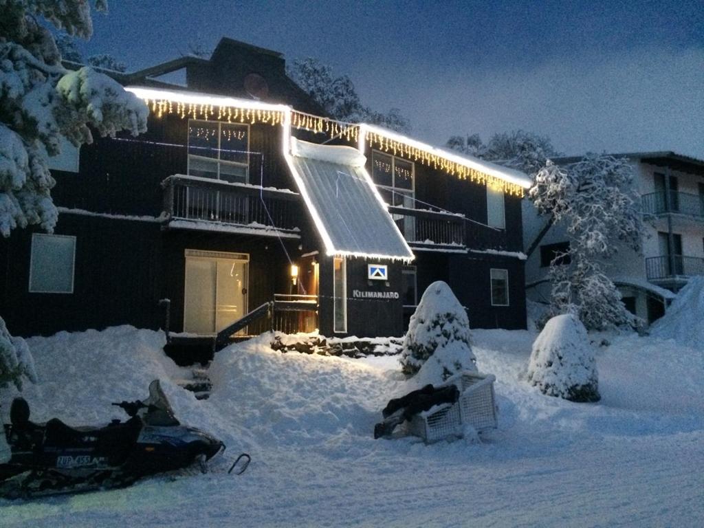 a building covered in snow with lights on it at Kilimanjaro Alpine Apartments in Falls Creek