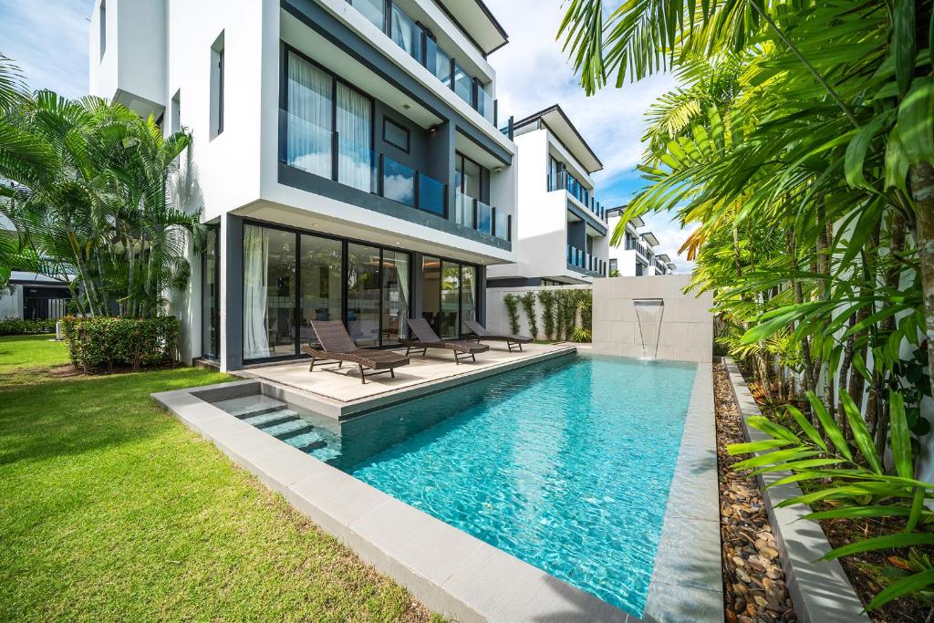 a swimming pool in the backyard of a house at Modern Minimalist 6 Bedroom Light Luxury Villa Private Pool Golf Course Laguna Park in Ban Phru Champa