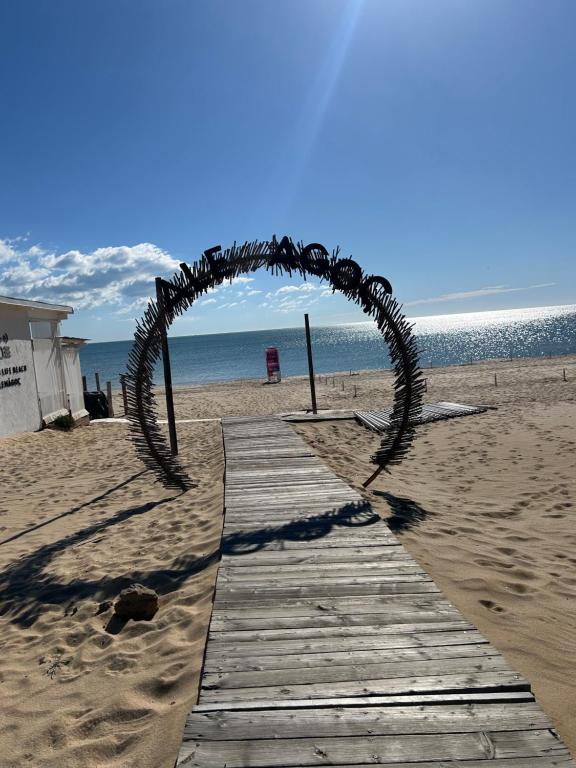 an arch on a wooden path on the beach at Студио Комфорт, Смокиня,Созопол,Затворен комплекс,4 басейна, 1-ва линия море in Sozopol