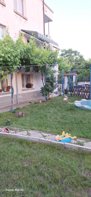 a yard of a house with a sandbox in the grass at Къща за гости ЕДЕЛВАЙС in Chernomorets