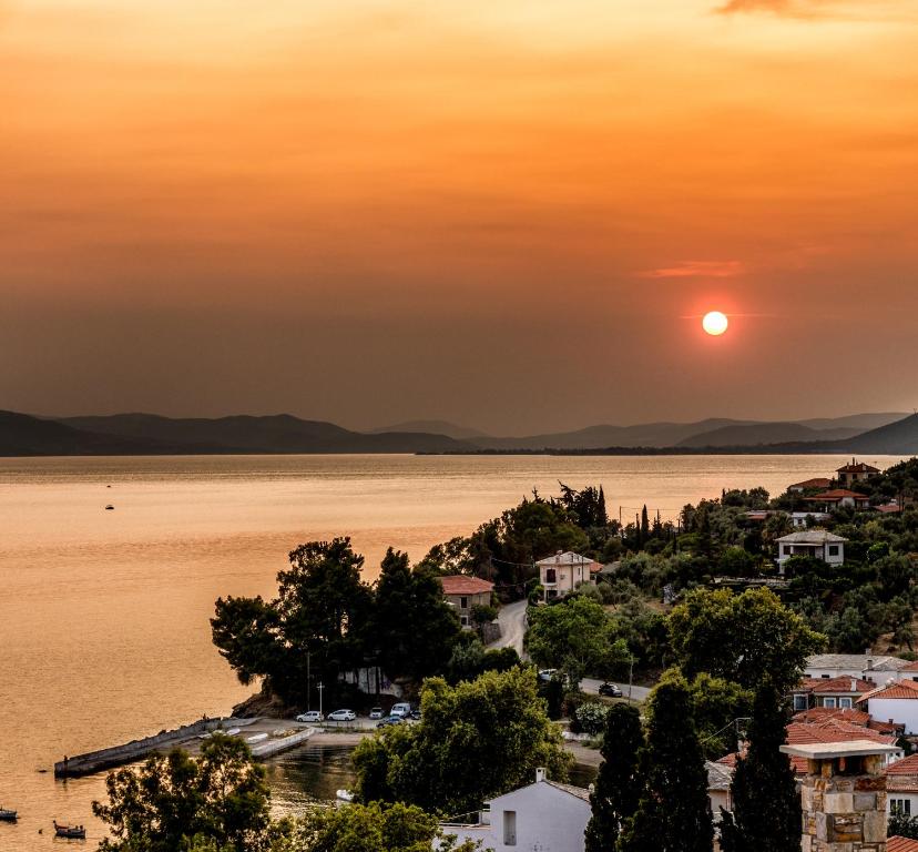 a sunset over a city and the water at Vista Mare 2 in Afissos