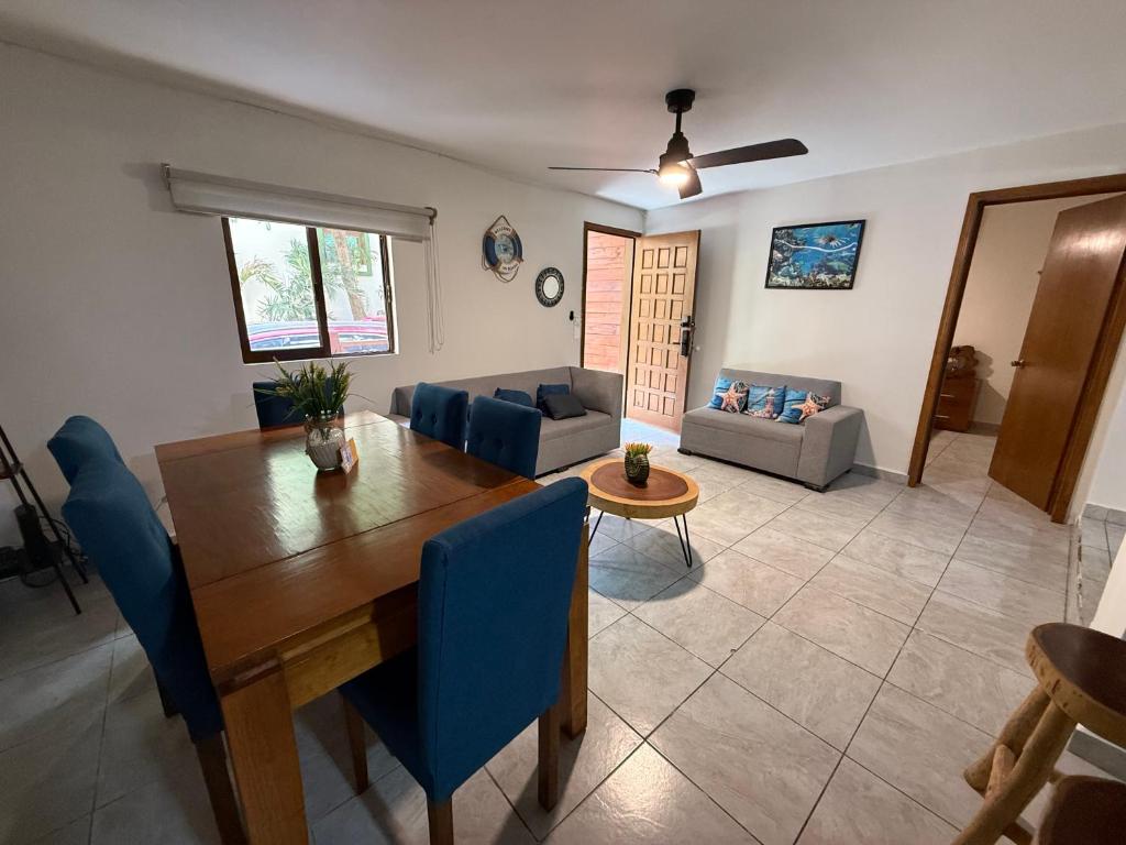 ein Wohnzimmer mit einem Holztisch und blauen Stühlen in der Unterkunft blue angel 4 in Playa del Carmen
