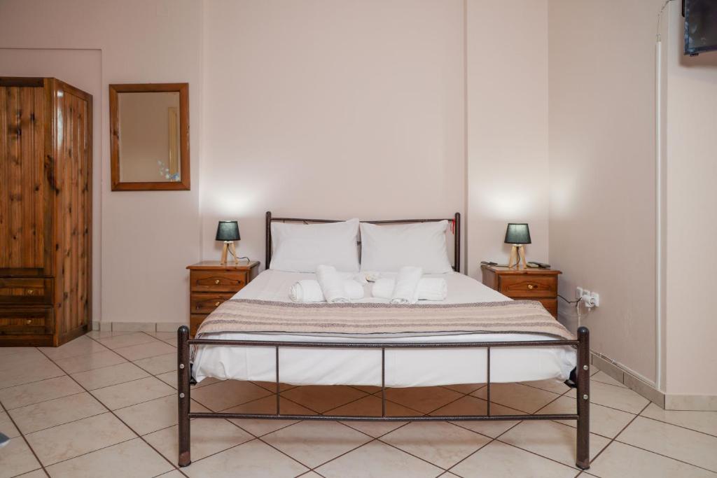 a bedroom with a bed with two night stands and two lamps at Homely Escape in Chios