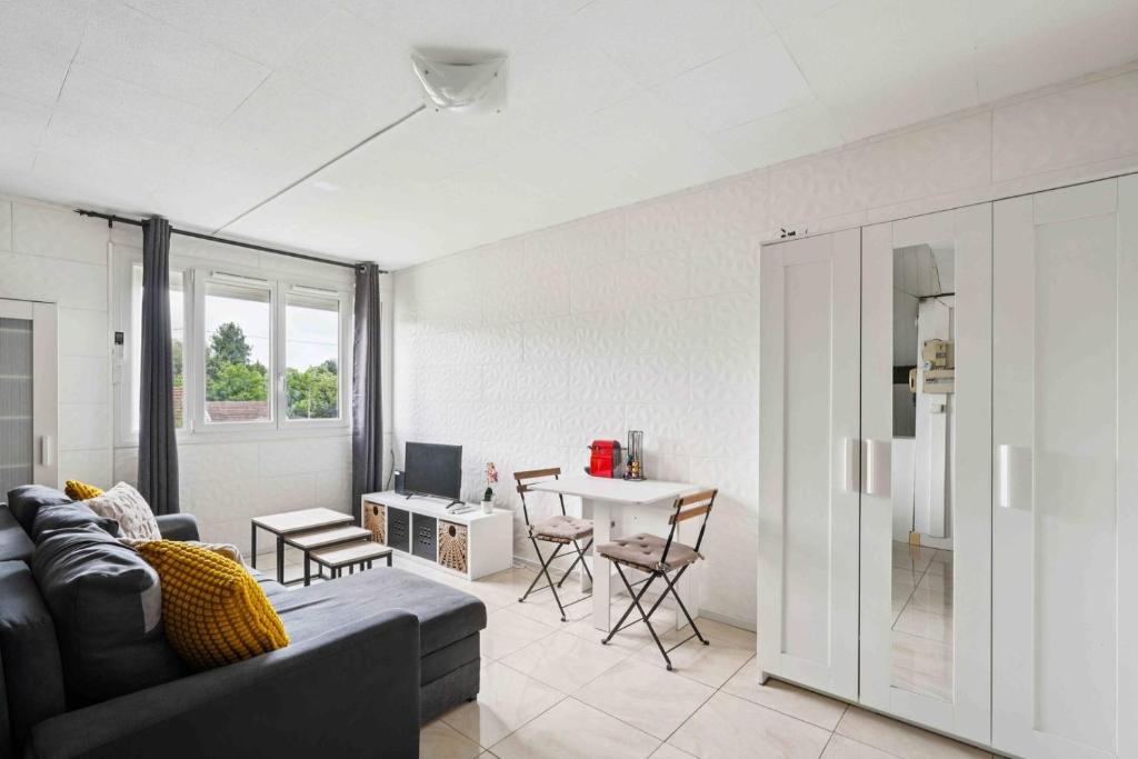 un salon avec un canapé et une table dans l'établissement Le Charpenté, à Paray-Vieille-Poste