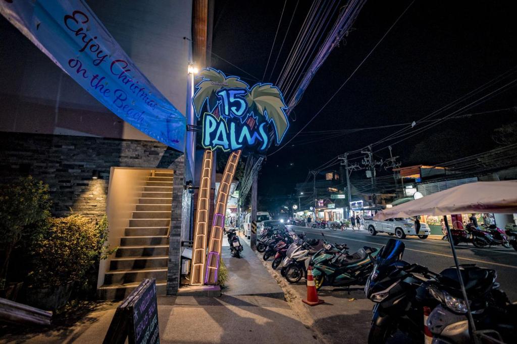 a sign on a building with motorcycles parked on the street at 15 Palms Beach Resort in Ko Chang