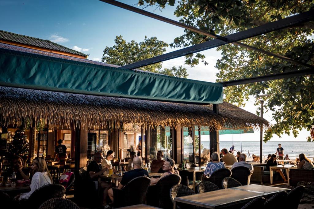 a group of people sitting in chairs at a restaurant at 15 Palms Beach Resort in Ko Chang