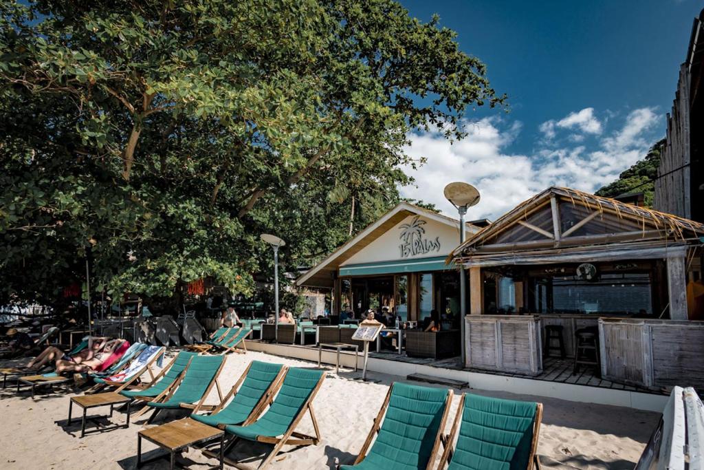 a group of lawn chairs sitting on a beach at 15 Palms Beach Resort in Ko Chang