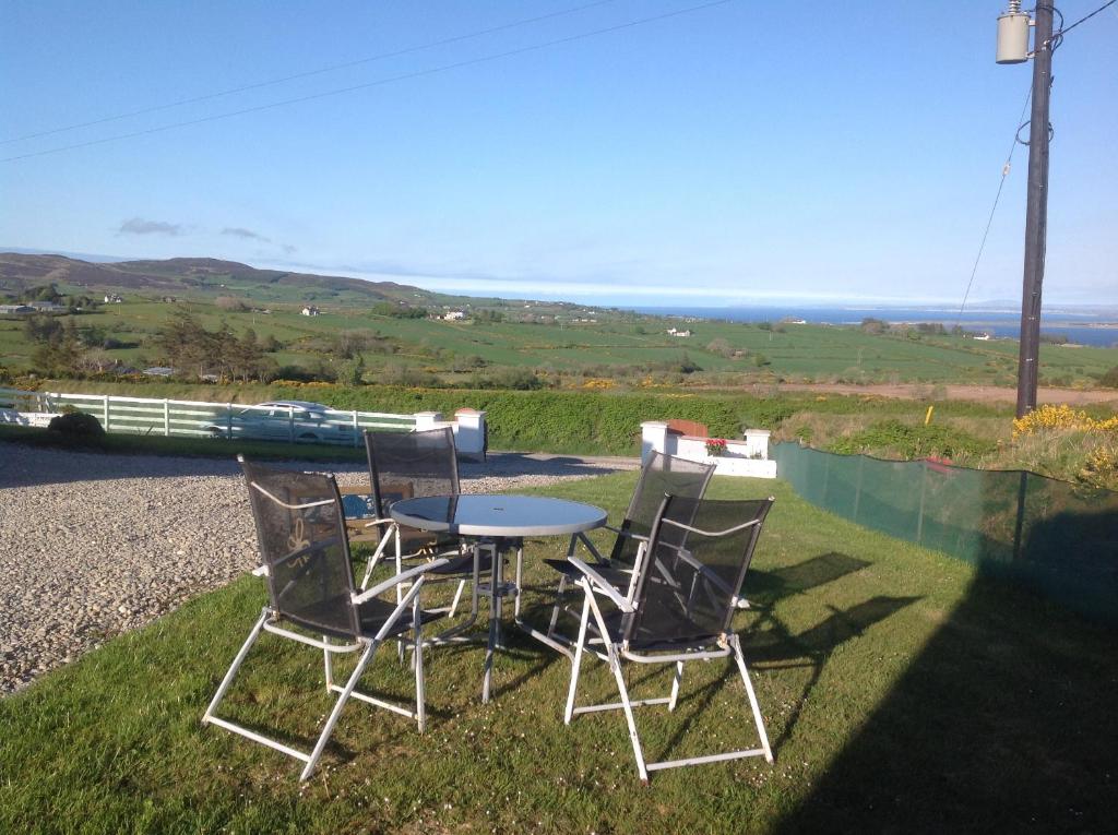a table and chairs sitting on the grass at Rosie's Cottage in Moville
