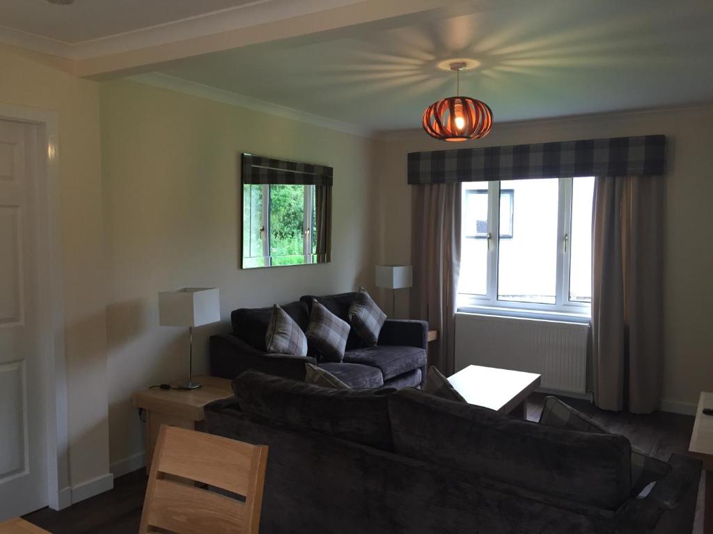 a living room with a couch and a window at Bruce's Cottage in Stirling