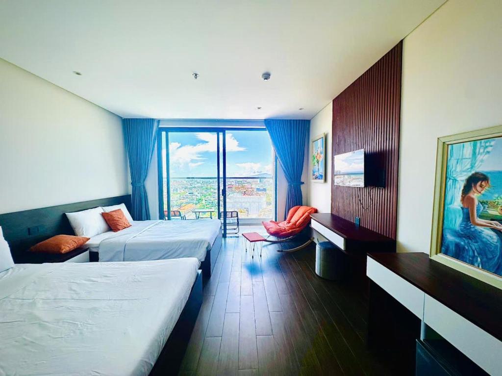 a hotel room with two beds and a balcony at Apec Whydham Tuy Hoa Phu Yen Hotel & Apartment in Tuy Hoa